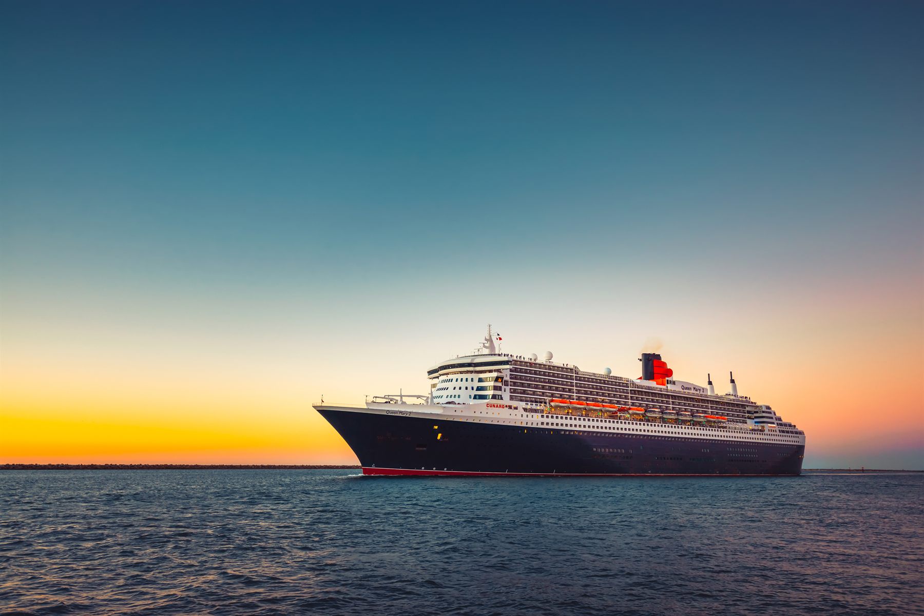 Cunard’s ocean liner Queen Mary 2 at sea at sunset